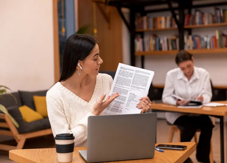 Woman reading a magazine feature in a cafe, representing editorial interviews