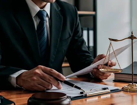 Lawyer at a desk beside scales of justice, representing professional authority