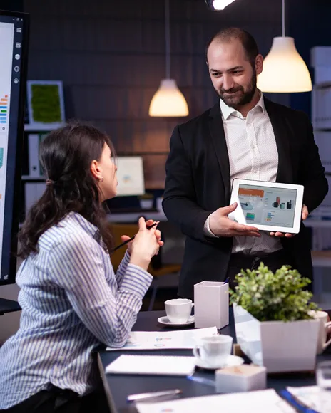 Two colleagues reviewing a tablet in an office