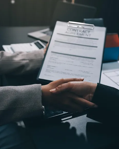 Hands passing a policy document across a desk, representing a platform takedown request