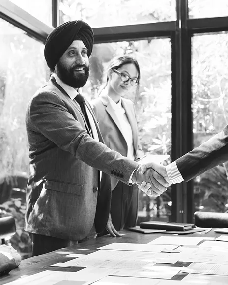 Two business partners shaking hands by a window, representing brand trust