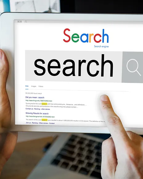 Hands holding a tablet showing a search page, representing Google search visibility