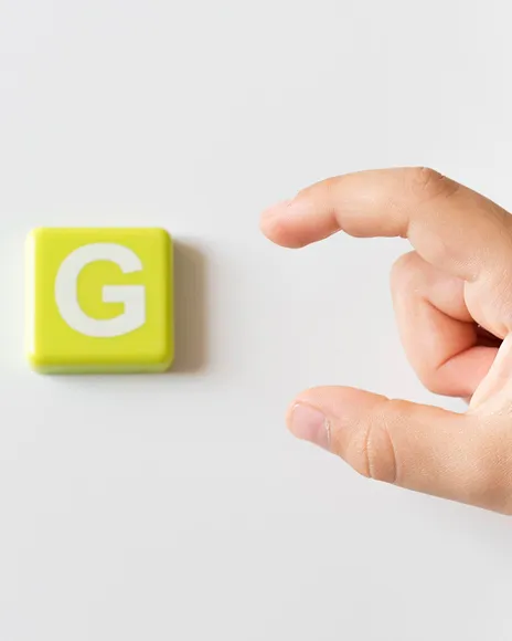 Hand holding a yellow Google G block, representing Google first-page control