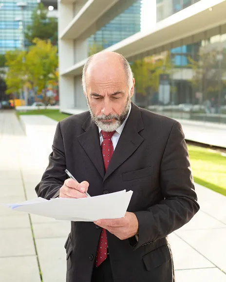 Older executive reviewing a document, representing an outdated article ranking on Google