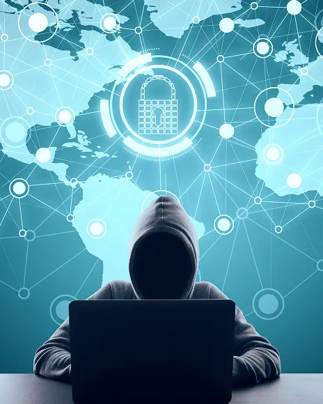 Hooded figure at a laptop over a world network map, representing coordinated online abuse