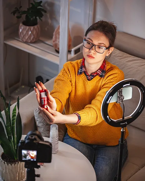 Content creator filming with a ring light, representing brand abuse on TikTok