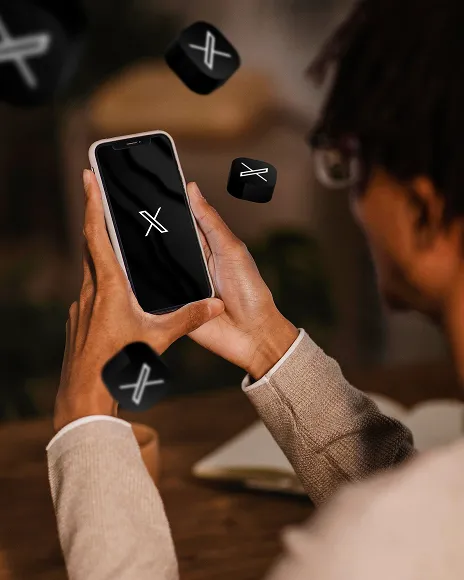 Hand holding a phone showing the X logo, representing defamatory posts on X