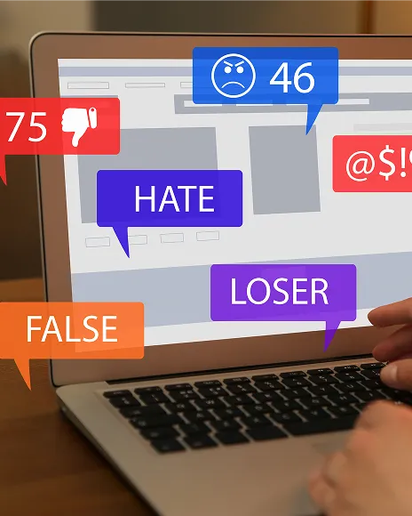 Laptop showing hateful comments and negative reactions, representing a Reddit harassment thread