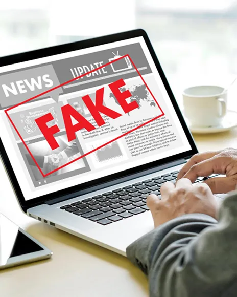 Laptop showing a news page stamped FAKE, representing false blog accusations