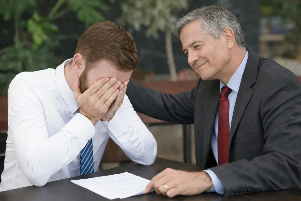 A professional comforting a colleague who is distressed over damaging online content